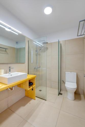 a bathroom with a sink and a toilet and a shower at Hotel Kamelo in Vari