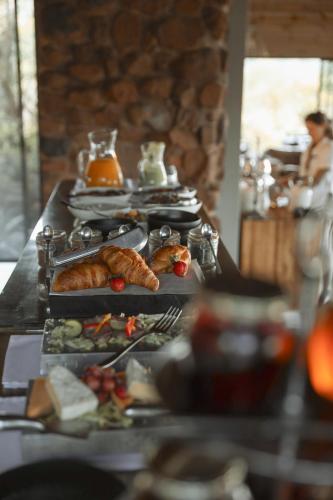 a buffet with plates of food on a table at Leopard Mountain Safari Lodge in Manyoni Private Game Reserve