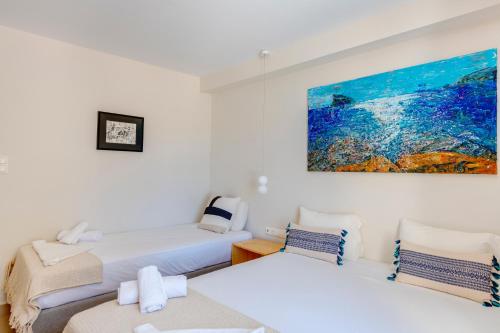 a room with two beds and a painting on the wall at Hotel Kamelo in Vari
