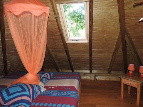 a room with a bed and a window in a cabin at Insolite Ara Wakan / Ma cabane in Pointe-Noire