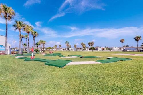 a row of green golf balls on a grass field at Long Island Village Texas in Port Isabel