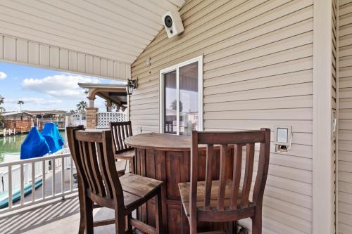 a wooden table and chairs on a porch with a window at Long Island Village Texas in Port Isabel