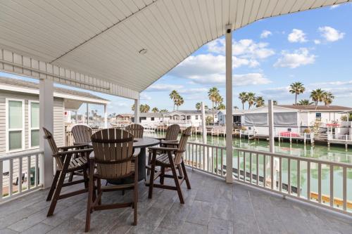 a porch with a table and chairs and a view of the water at Long Island Village Texas in Port Isabel