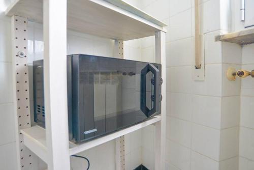 a microwave oven on a wall in a kitchen at Casa Lella - VADOALMARE Immobiliare in Savona