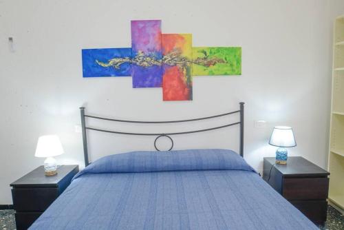 a bedroom with a blue bed with two night stands and two lamps at Casa Lella - VADOALMARE Immobiliare in Savona