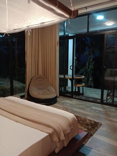 a bedroom with a bed and a balcony with a table at Lush In Ella in Ella