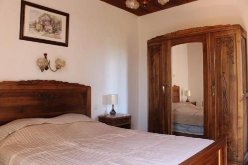 una camera da letto con un letto grande e uno specchio di Authentique ferme périgourdine, à 5km au sud de Sarlat, 1km de la rivière a Vitrac