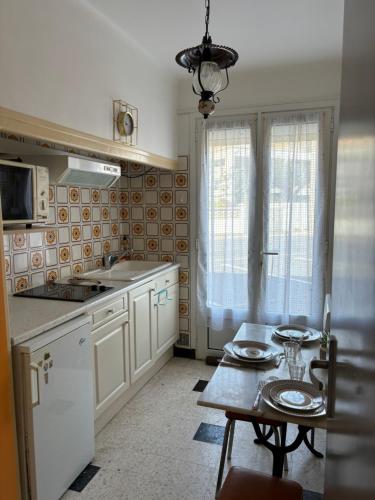 une cuisine avec une table et un astérisque d'astryastryastryasteryasteryasteryastery dans l'établissement Le Géranium, à Port-la-Nouvelle