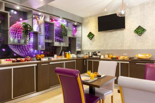 a dining room with a table and purple chairs at Comfort Hotel Orléans Olivet in Olivet