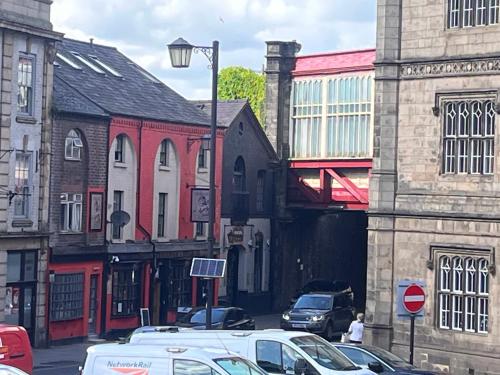 a city street with cars parked in front of buildings at Tumbledown Hotel in Shrewsbury