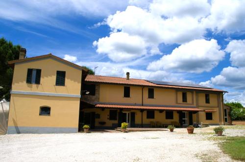 a large house with a sky with clouds at Agriturismo Ai Prati in Perugia