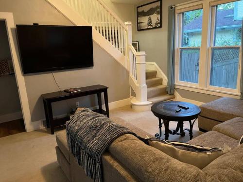 a living room with a couch and a flat screen tv at 515Escape - Near downtown, private backyard, firepit, bbq, fun! in Lake Geneva