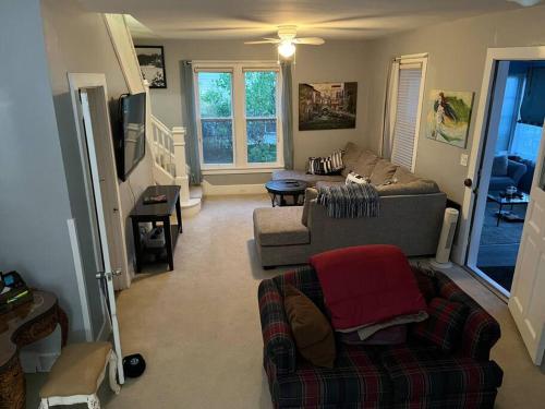 a living room with a couch and a tv at 515Escape - Near downtown, private backyard, firepit, bbq, fun! in Lake Geneva