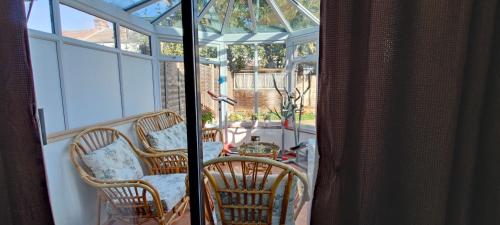 a screened in porch with two chairs and a table at comfortable room in Goodmayes
