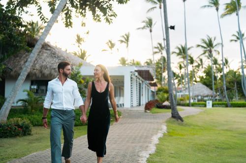 a man and a woman walking down a sidewalk at Wyndham Alltra Samana All Inclusive Resort in Las Galeras