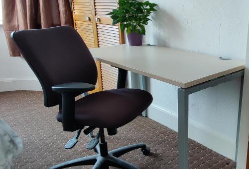 a black office chair sitting in front of a desk at comfortable room in Goodmayes