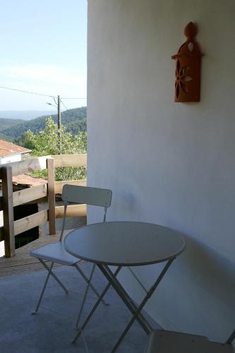 a table and a chair sitting next to a wall at Casa Laranjeira in Vale de Cameiro