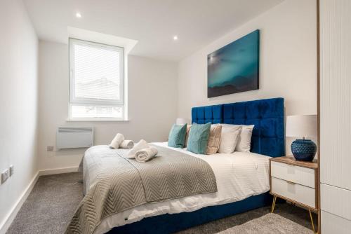 a bedroom with a blue and white bed and a window at Lovely 1 Bedroom Apartment in Central Rotherham in Rotherham
