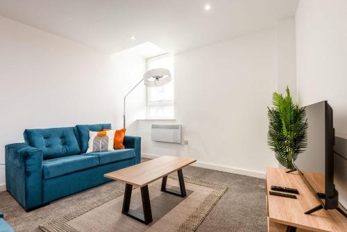 a living room with a blue couch and a table at Lovely 1 Bedroom Apartment in Central Rotherham in Rotherham
