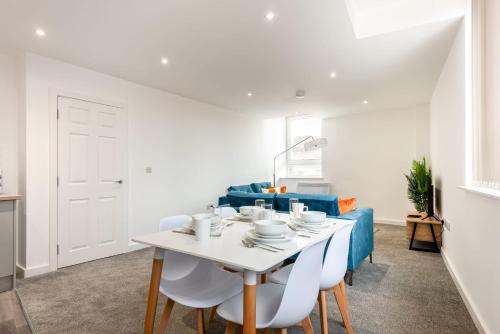 a white dining room with a white table and chairs at Lovely 1 Bedroom Apartment in Central Rotherham in Rotherham