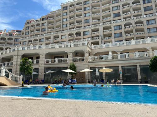 Una piscina de hotel frente a un gran edificio. en South Bay Luxury Apartment, en Varna