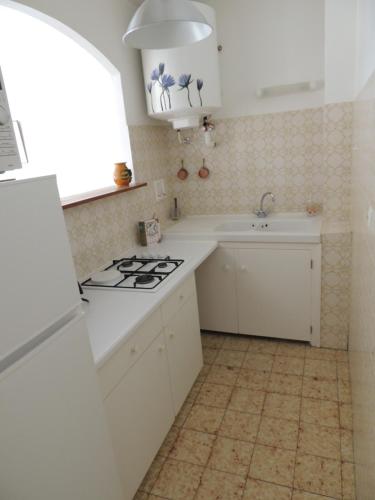 une cuisine avec une cuisinière et un évier dans l'établissement T2 Centre-ville, proche plage, à Sanary-sur-Mer