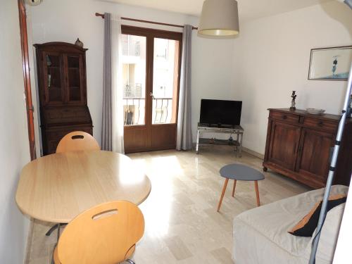 un salon avec une table, des chaises et une télévision dans l'établissement T2 Centre-ville, proche plage, à Sanary-sur-Mer