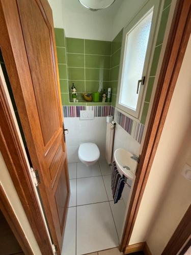 a small bathroom with a toilet and a sink at La Villa Boutrois in Isigny-sur-Mer