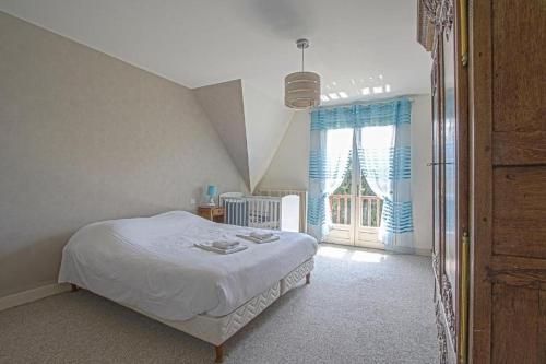 a bedroom with a bed and a large window at La Villa Boutrois in Isigny-sur-Mer