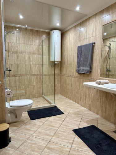 a bathroom with a shower and a toilet and a sink at South Bay Luxury Apartment in Varna City