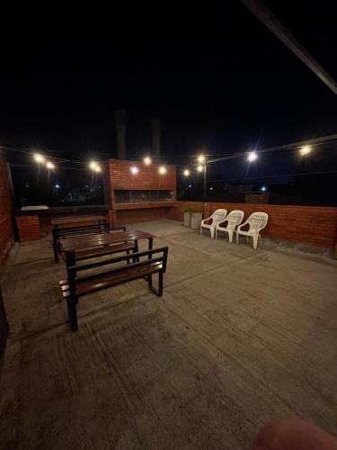 a group of benches sitting on a patio at night at Costalago Suites Hotel in Villa Carlos Paz