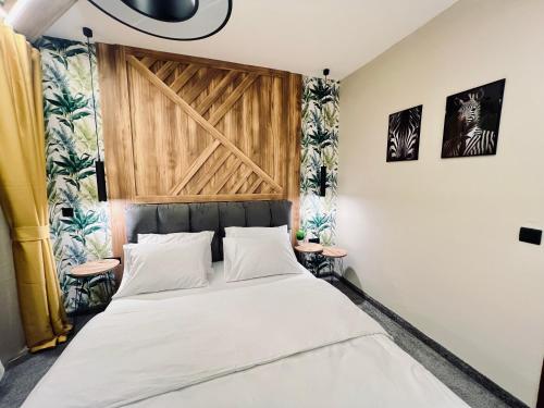 Un dormitorio con una cama con cabecero de madera. en NJ Luxury breeze, en Varna