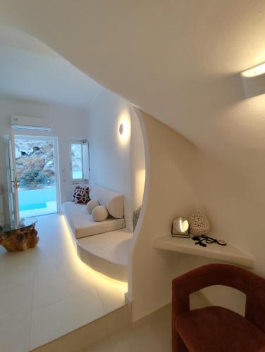 a white living room with a couch and a table at The Magic Luxury Cave Suites in Vóthon