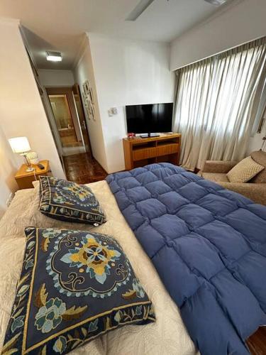 a bedroom with a large blue bed and a couch at Lugones House in Cordoba