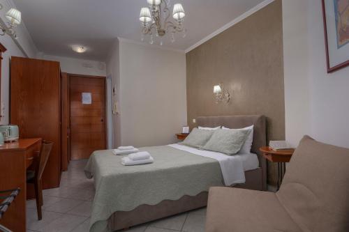 a hotel room with a bed and a chair at Paradise in Nea Vrasna