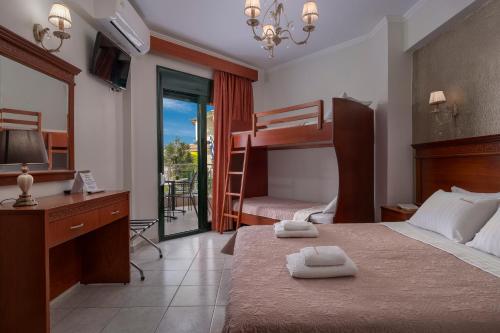 a bedroom with a bed and a desk and bunk beds at Paradise in Nea Vrasna
