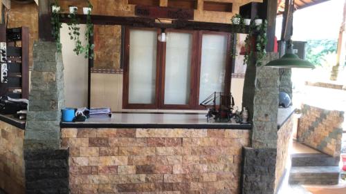 a kitchen with a brick wall and a window at The Puji's Hostel in Batununggul