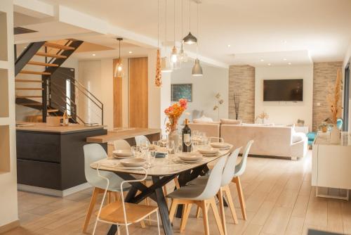 a dining room and living room with a table and chairs at Les Villas Chamontines - La Villa des Chênes in Labeaume