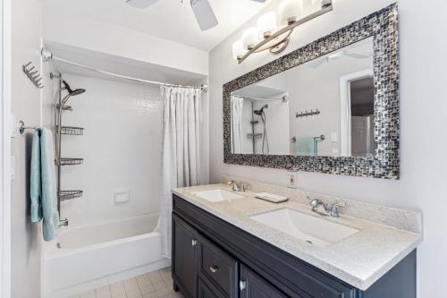 a bathroom with a sink and a mirror at Charming Heated Pool Home - 3 miles to the Beach, Pet and Family Friendly -Available Year Round! in Bonita Springs