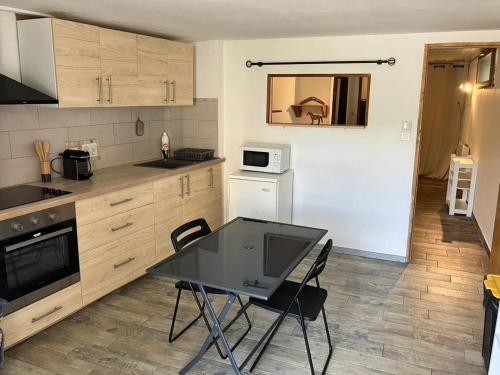a kitchen with a table and chairs in a room at appartement deux pieces in Notre-Dame-de-Londres
