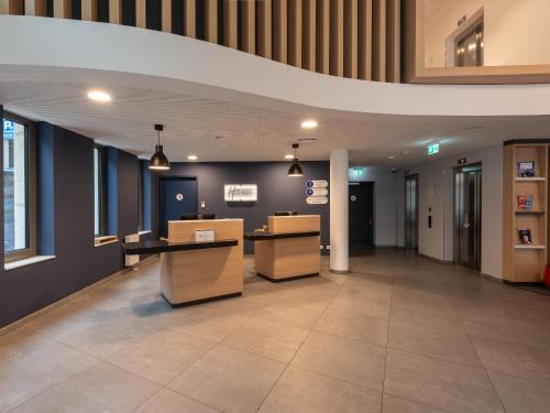 an empty lobby of an office building with desks at Holiday Inn Express Heilbronn by IHG in Heilbronn