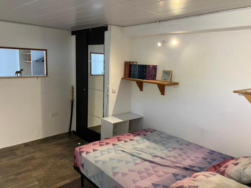 a bedroom with a bed and a shelf on the wall at appartement deux pieces in Notre-Dame-de-Londres