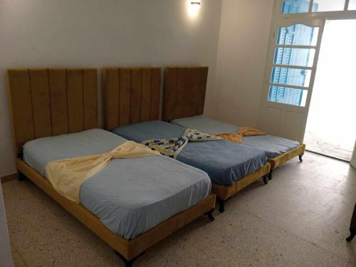 two twin beds in a room with a window at Résidence lalla baya appart 1 in Sousse