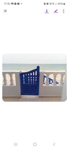 a blue chair on the beach with the ocean in the background at Résidence lalla baya appart 1 in Sousse
