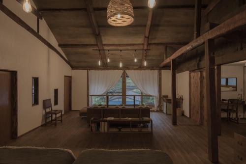 a living room with a couch and a large window at ruisseau in Ogawa