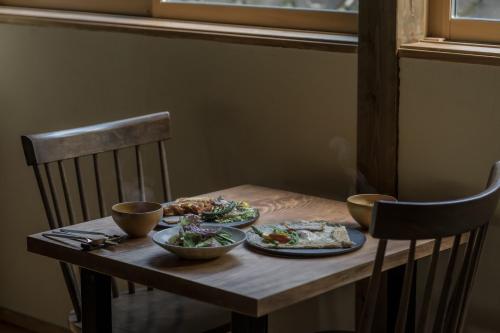 a wooden table with two plates of food on it at ruisseau in Ogawa