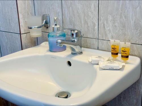 a bathroom sink with two glasses of beer on it at Peter's Place Studios & Suites in Faliraki