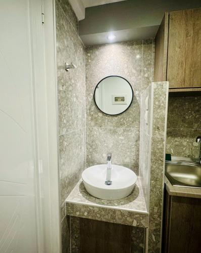 a bathroom with a sink and a mirror at Peter's Place Studios & Suites in Faliraki