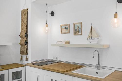 a white kitchen with a sink and a counter at La Casita Blanca in Barbate