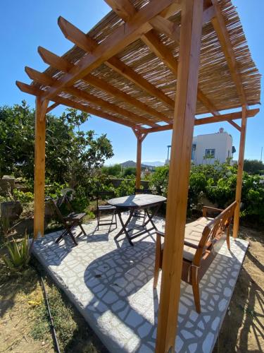 a wooden pergola with a table and chairs on a patio at Nektarios apartment in Mikri Vigla